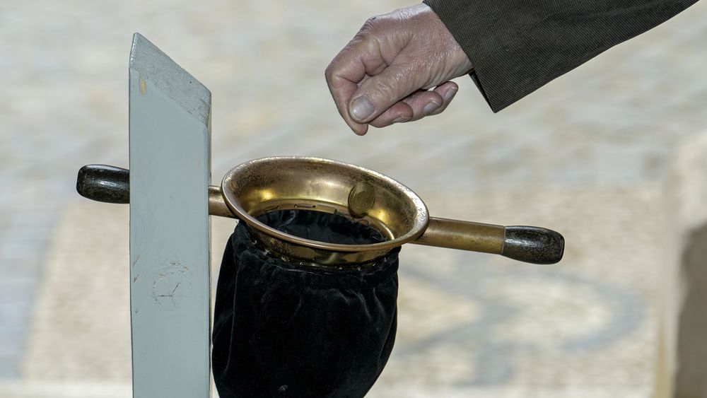 Symbolbild: Kollektenbeutel und Hand
